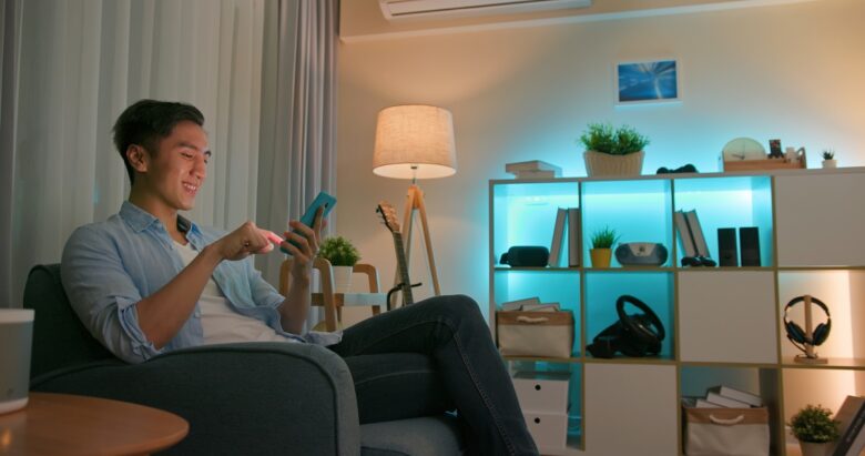Asian,Young,Man,Using,Smart,Home,App,To,Control,Light