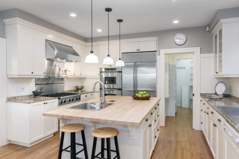 Amazing Luxury Kitchen Interior in white with wooden floor and kitchen island.