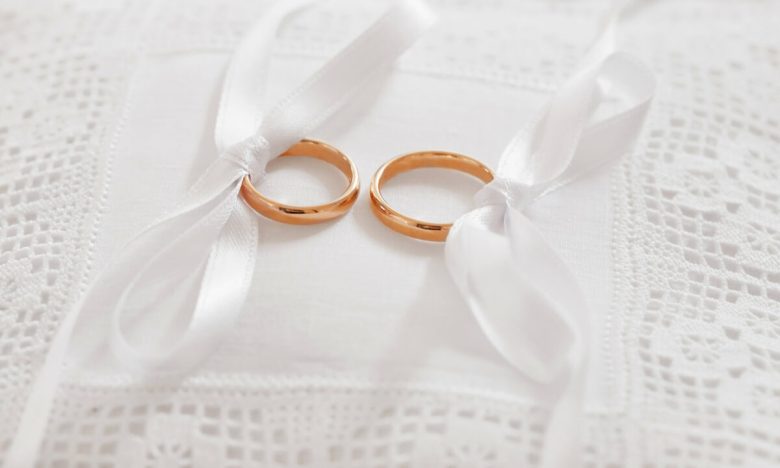 gold wedding rings on satin pillow