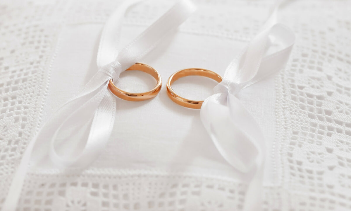 gold wedding rings on satin pillow
