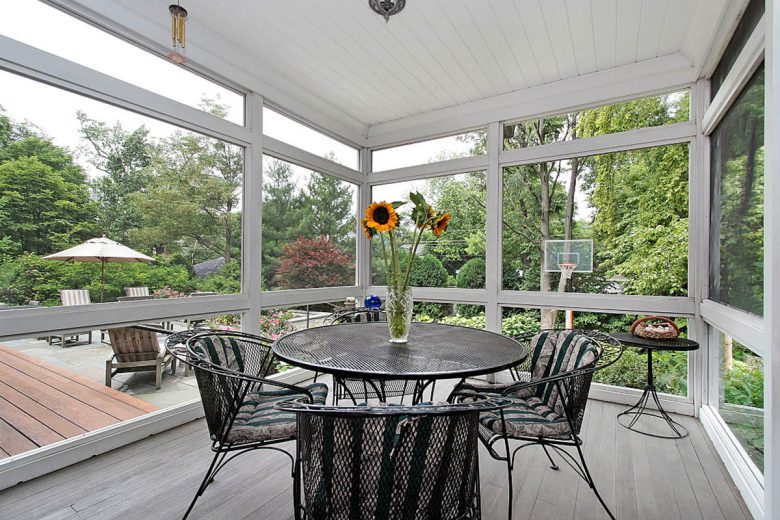Screened in porch with table and wood floor