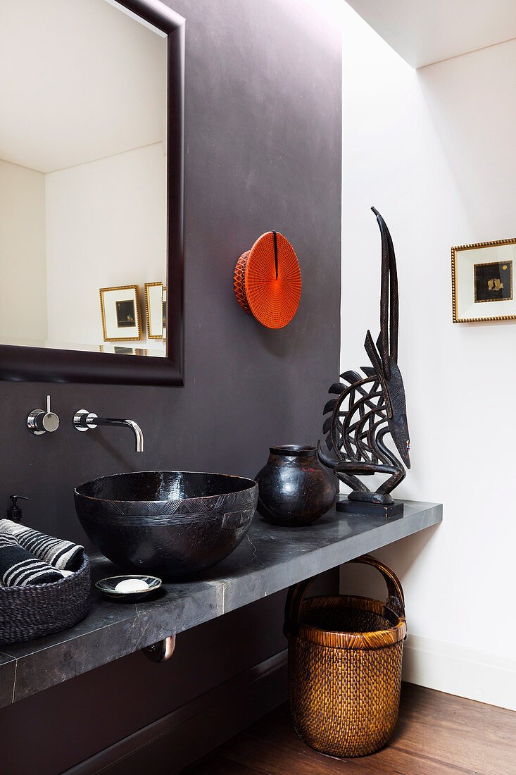 Bad im Ethnostil mit grauer Wand und schwarzer Deko