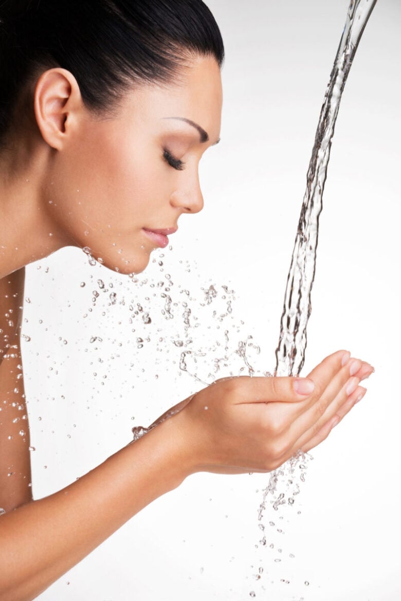 woman washing her clean face with water
