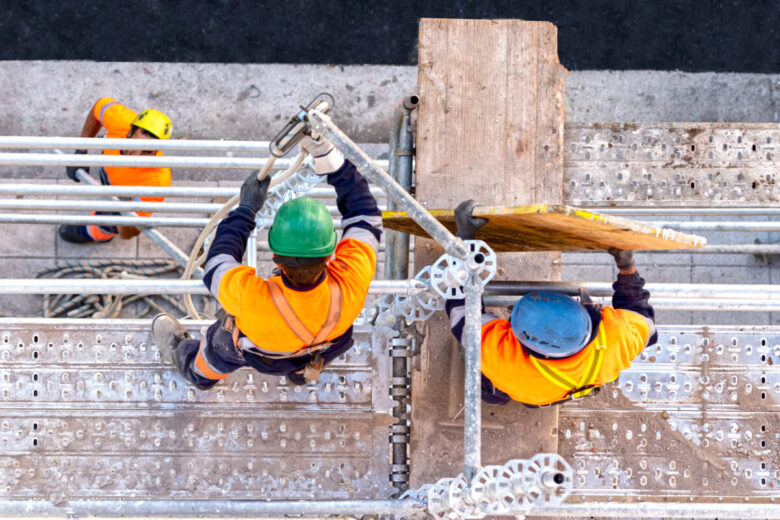Workers,Seen,From,Above,Setting,Scaffolding,On,A,Facade