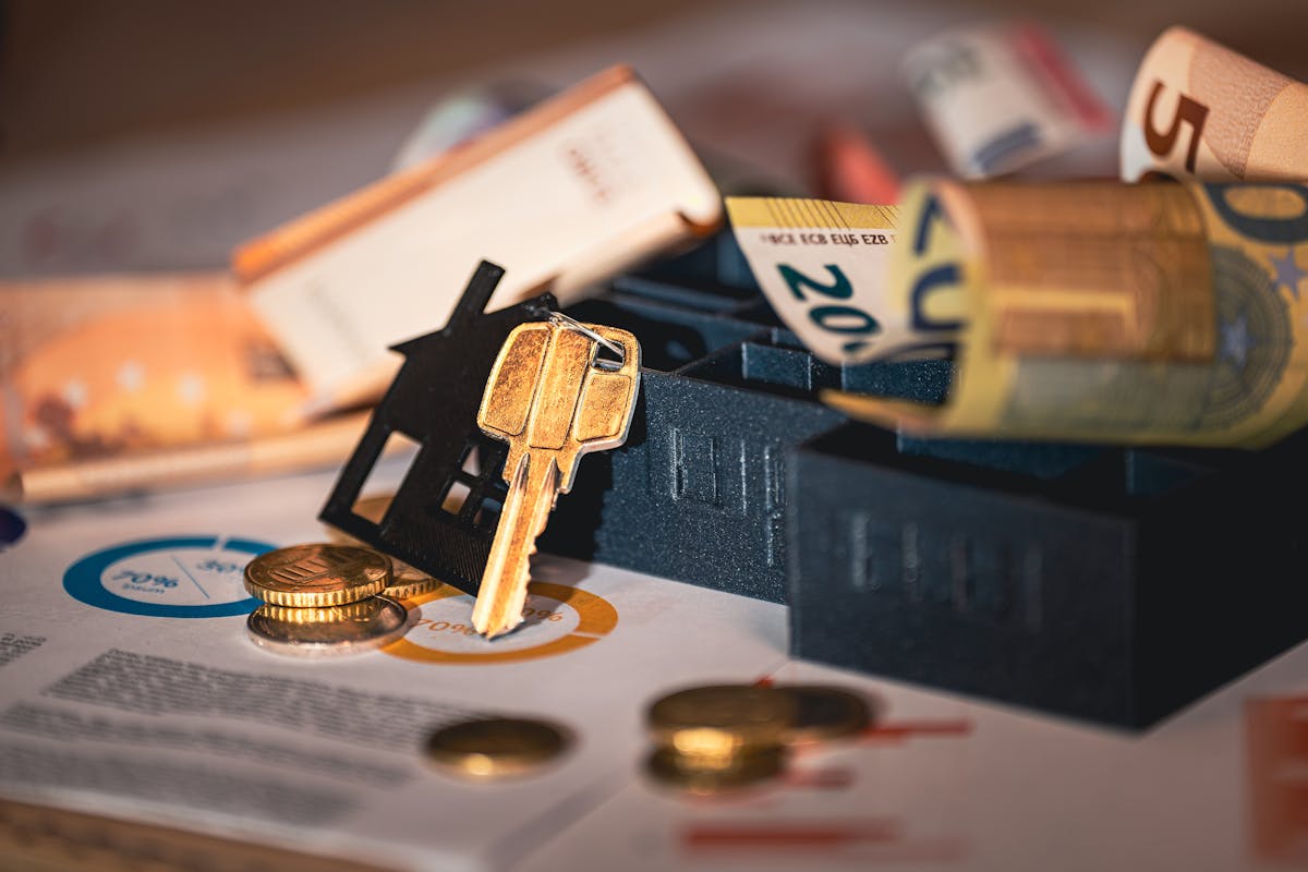 Close-up of house keys, euro bills, and charts symbolizing real estate investment and finance. Close-up of house keys, euro bills, and charts symbolizing real estate investment and finance.