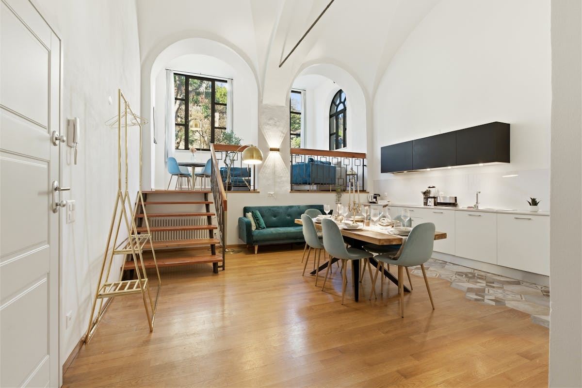 Stylish loft interior featuring a modern open kitchen and a cozy dining area. Stylish loft interior featuring a modern open kitchen and a cozy dining area.