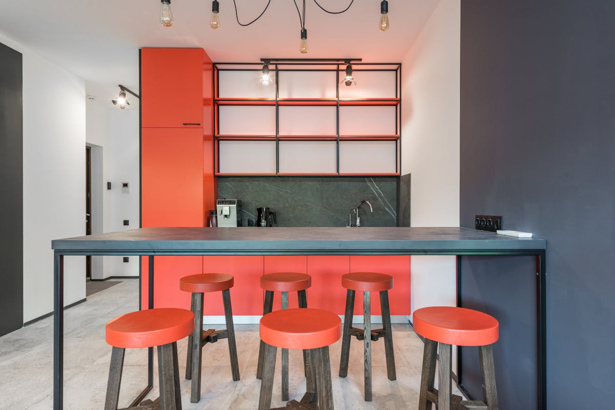 Contemporary kitchen with table and chandelier against empty shelves above coffee machine in light house Contemporary kitchen with table and chandelier against empty shelves above coffee machine in light house
