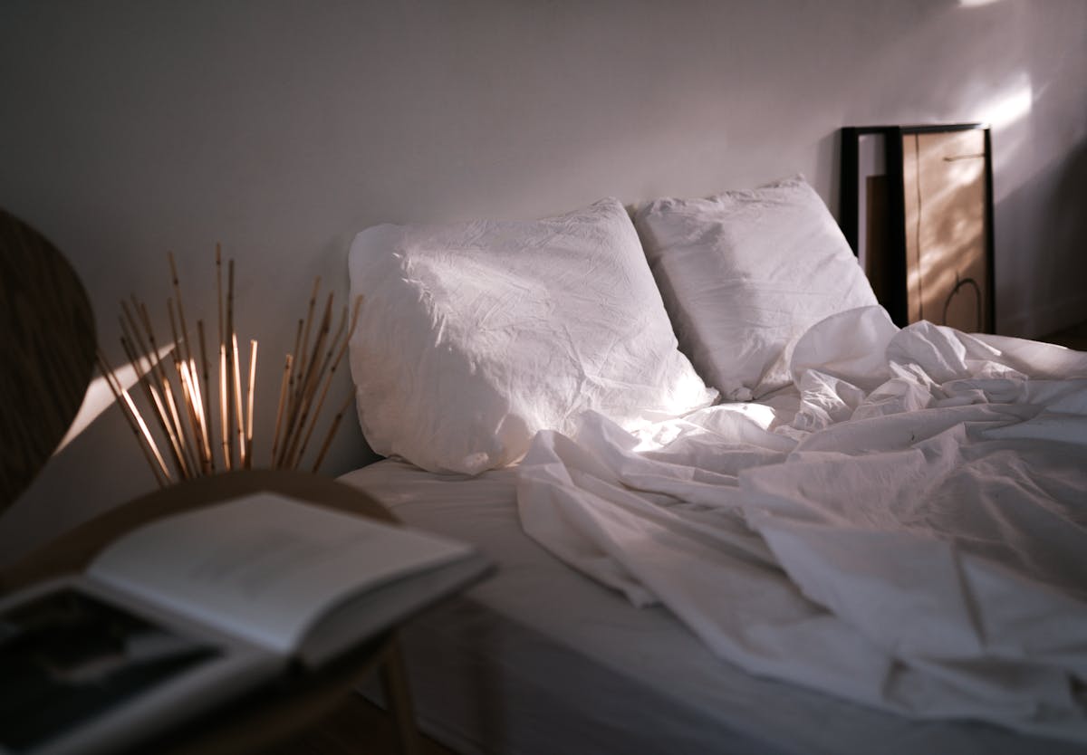 A serene bedroom scene showcasing soft linen, pillows, and ambient natural light, creating a calm atmosphere. A serene bedroom scene showcasing soft linen, pillows, and ambient natural light, creating a calm atmosphere.