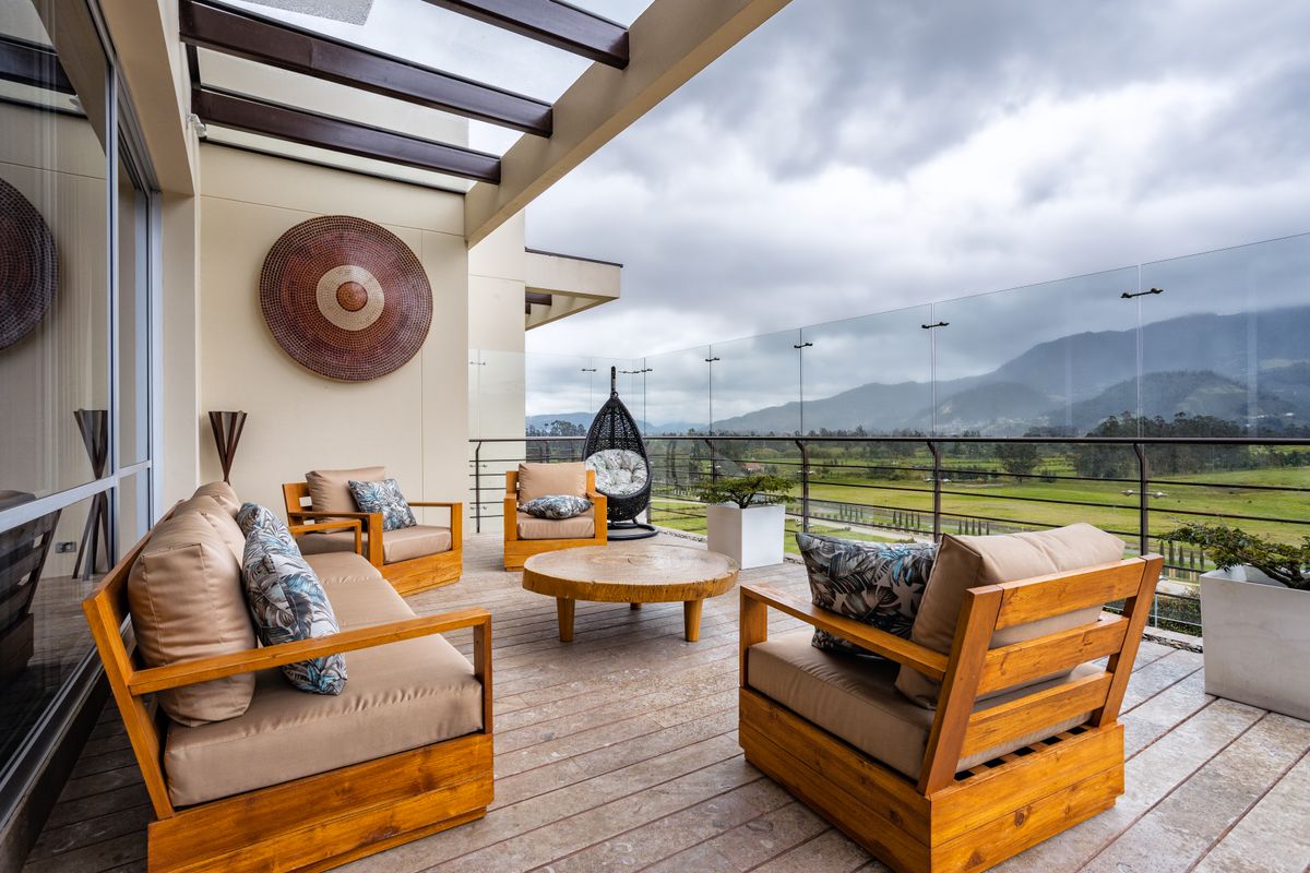 Stylish outdoor space featuring wooden furniture and mountainous backdrop in Sopó, Colombia. Stylish outdoor space featuring wooden furniture and mountainous backdrop in Sopó, Colombia.