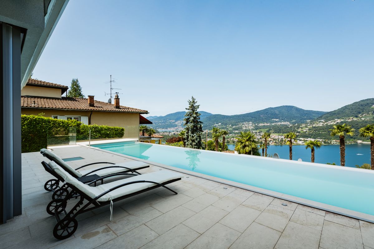 Elegant lakeside infinity pool with stunning mountain and water views, perfect for relaxation and summer leisure. Elegant lakeside infinity pool with stunning mountain and water views, perfect for relaxation and summer leisure.