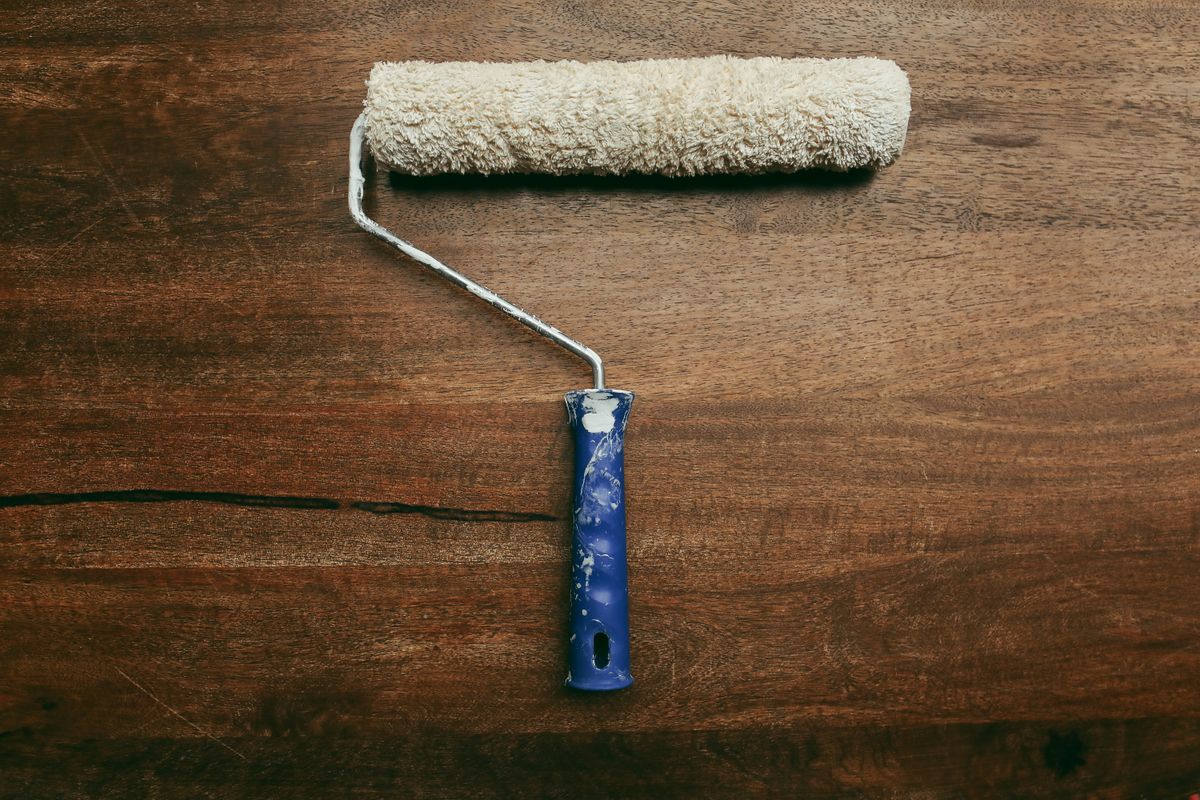 A worn paint roller placed on a wooden surface, ideal for DIY home improvement visuals. A worn paint roller placed on a wooden surface, ideal for DIY home improvement visuals.