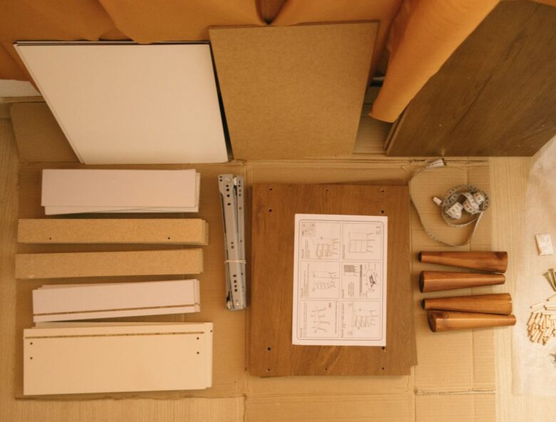 Top view of arranged pieces with instruction paper on carton before assembling furniture at home
