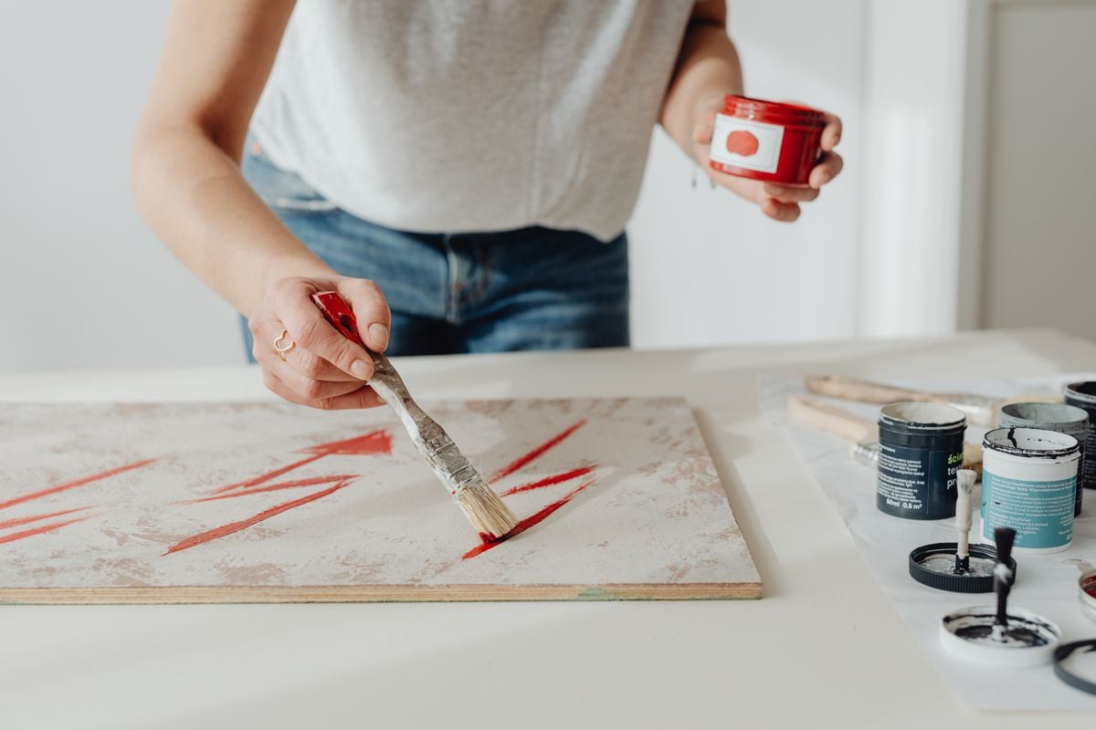 Hands painting red strokes on canvas, showcasing creativity and artistic expression. Hands painting red strokes on canvas, showcasing creativity and artistic expression.
