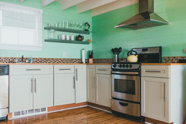 Contemporary kitchen with mint green walls and stainless steel appliances.