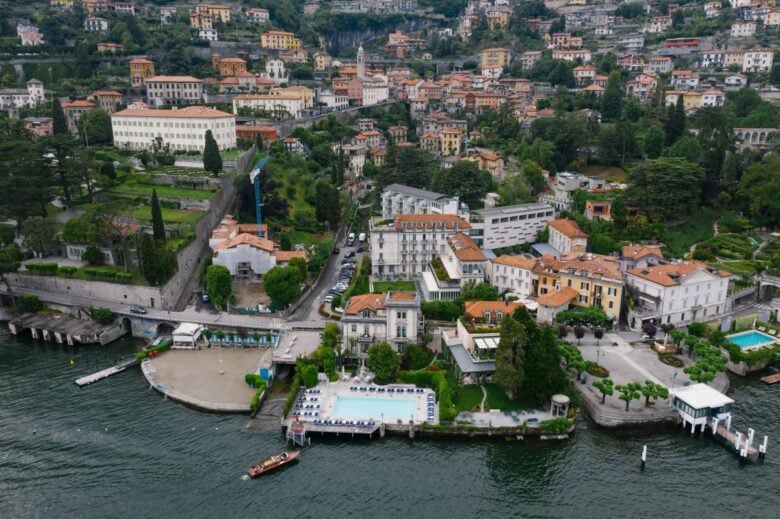 Stunning aerial view of a picturesque lakeside town in Italy, showcasing villas and lush greenery.