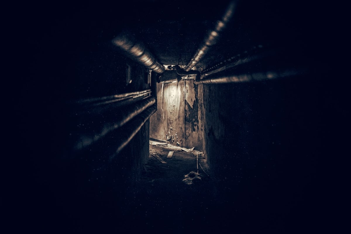 lighted brown tunnel with black metal pipes lighted brown tunnel with black metal pipes