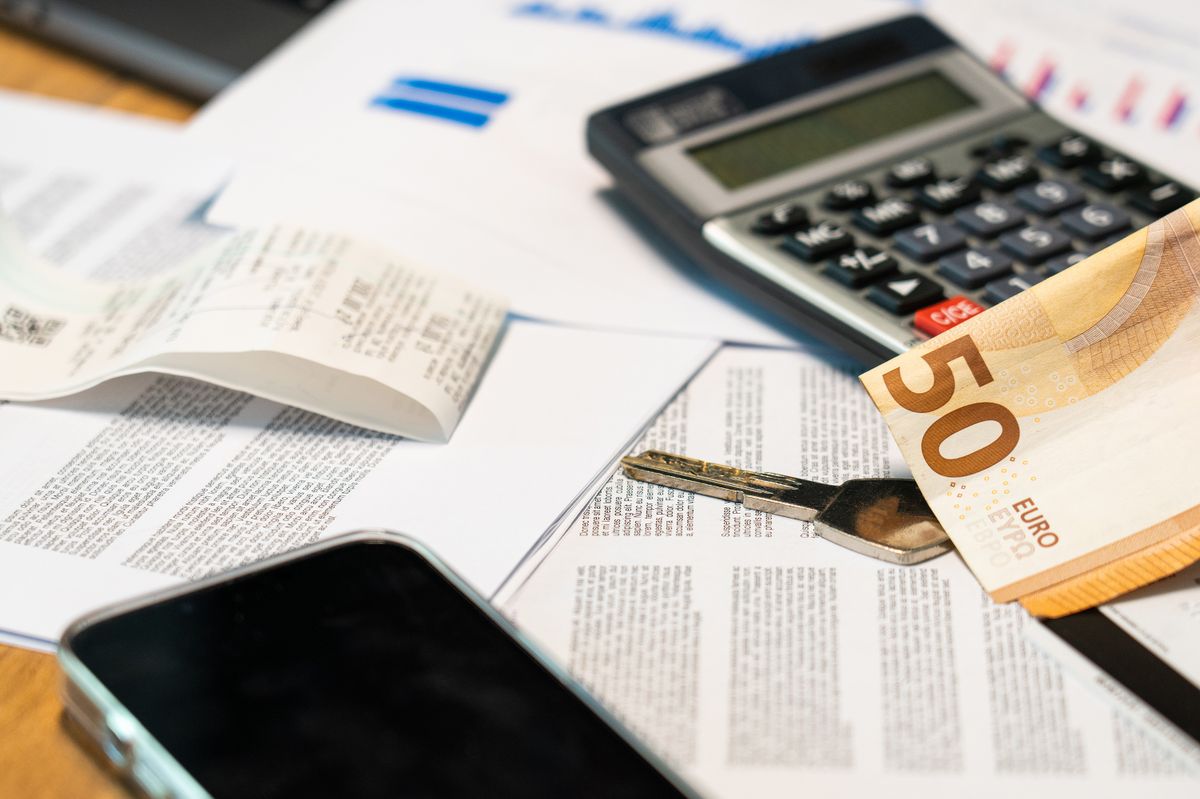 Flat lay of financial documents, euro note, calculator, smartphone, and key for budget management. Flat lay of financial documents, euro note, calculator, smartphone, and key for budget management.