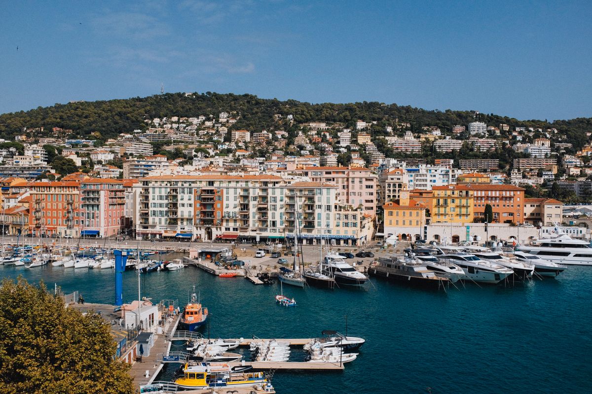A vibrant panorama of Cannes port showcasing luxury yachts, colorful buildings, and scenic hills. A vibrant panorama of Cannes port showcasing luxury yachts, colorful buildings, and scenic hills.
