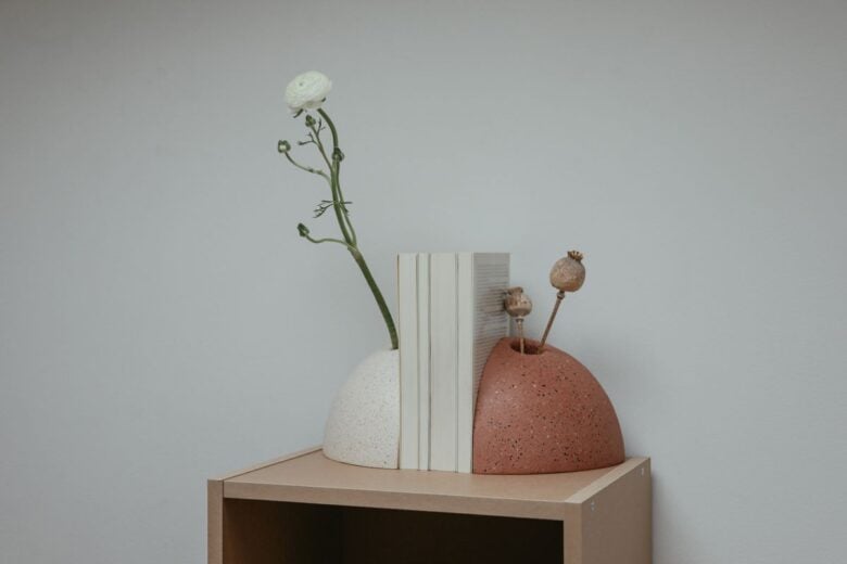 Elegant minimalist bookends with flowers on a wooden shelf. Perfect for interior decor.