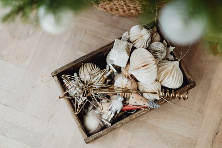 Aerial view of Christmas ornaments in a wooden box on a wooden floor.