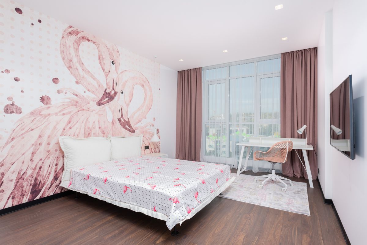 Interior of stylish room with soft bed against TV set and table with chair near window Interior of stylish room with soft bed against TV set and table with chair near window